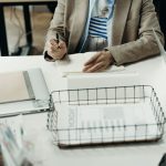 Profissional fazendo anotações em uma mesa de escritório, em contexto de planejamento do trabalho
