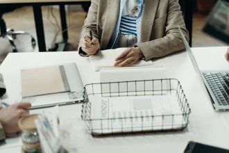 Profissional fazendo anotações em uma mesa de escritório, em contexto de planejamento do trabalho
