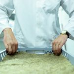 Cientista de jaleco manipula amostras em um laboratório de pesquisa.