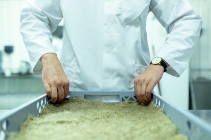 Cientista de jaleco manipula amostras em um laboratório de pesquisa.